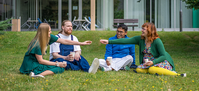 diskutujúci kolegovia sediaci v tráve